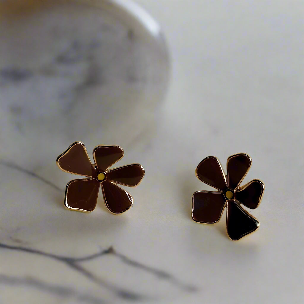 Pair of flower-shaped earrings on a beige background