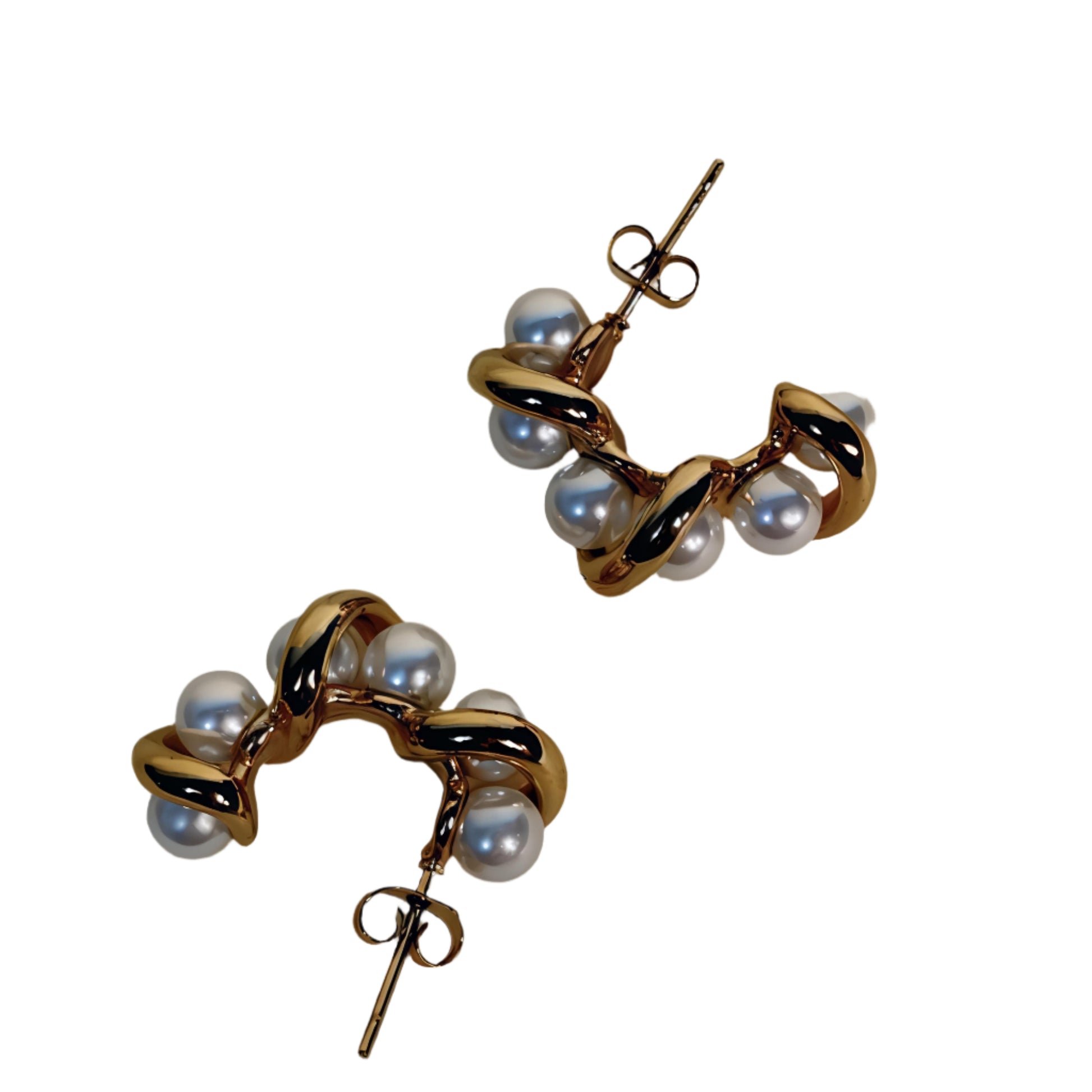 Pair of gold hoop earrings with pearls on a beige background
